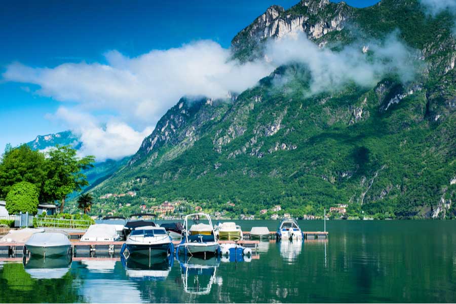 Het Lugano meer met boten in de haven van Porlezza