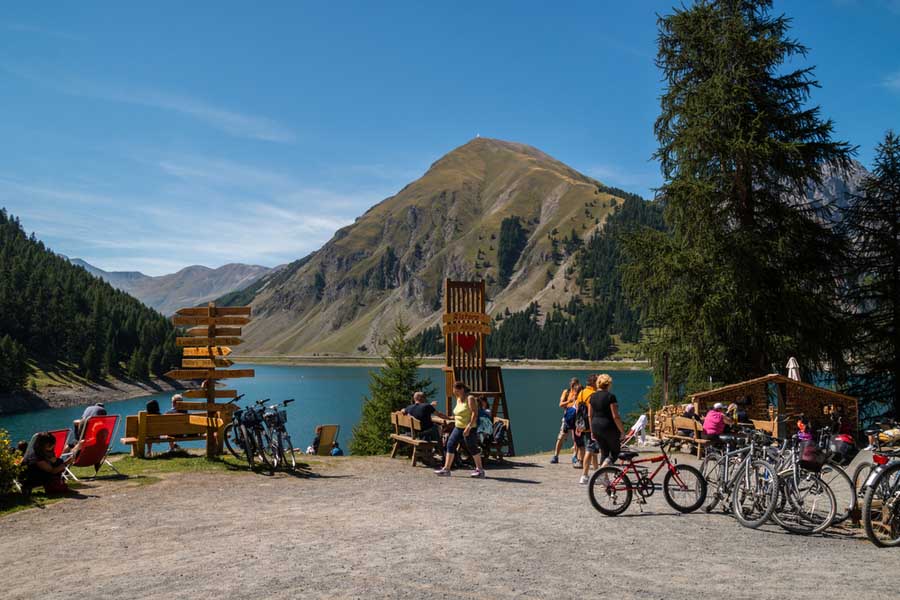 Groep fietsers bij het meer van Livigno met het Alta Valtellina gebergte