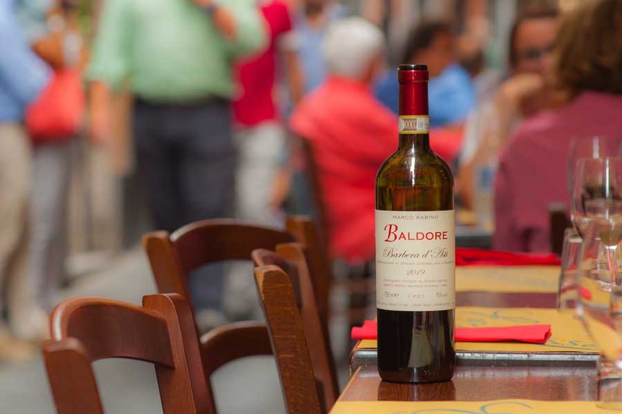Fles rode wijn bij restaurant in Asti